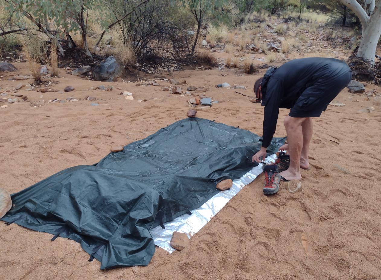 Fraser retrieving his boots from under my tarp. I had stashed them there earlier when rain seemed probable.